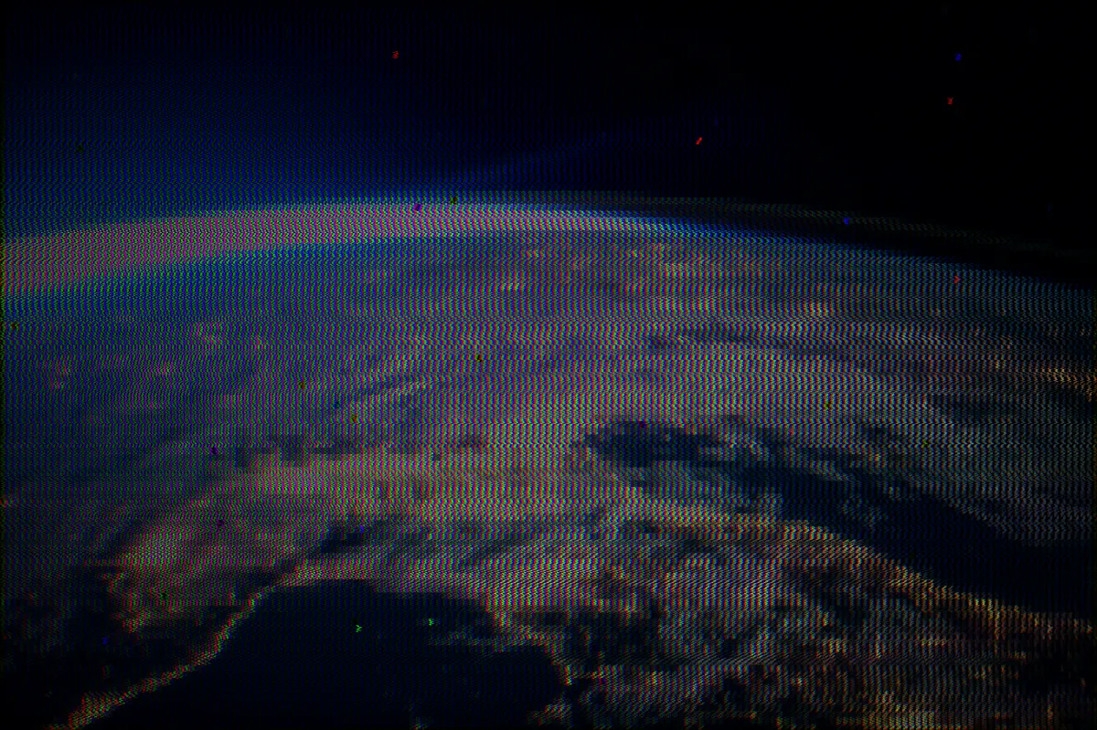A view of Earth from orbit at night, heavily distorted by CRT scanlines and rainbow chromatic aberration — the continents and city lights still just visible through the noise.